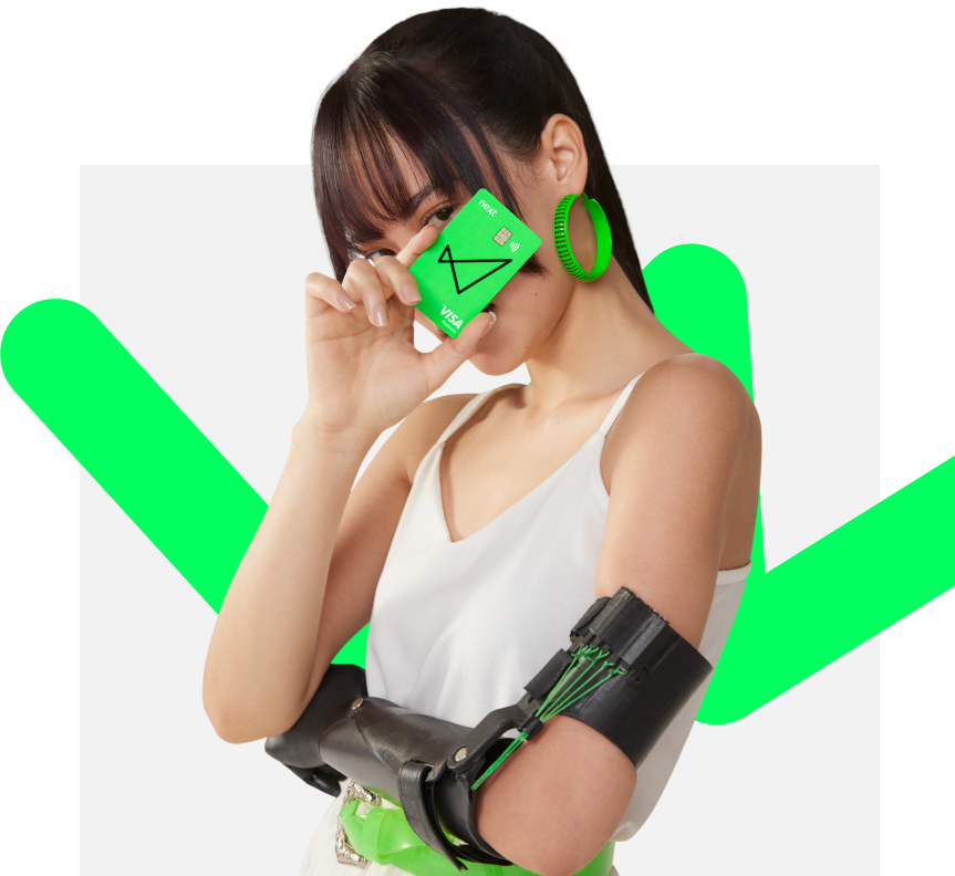 Uma mulher segura o cartão next na frente do seu rosto, enquanto cruza o outro braço envolta do seu corpo. Ela tem o cabelo escuro preso, usa uma blusa branca, brincos verde neon e possui uma prótese em seu braço.